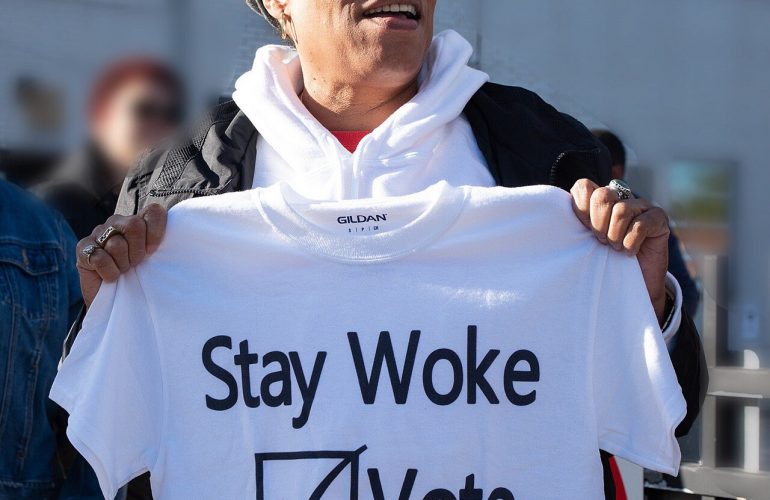 L'allora deputata statunitense Marcia Fudge mostra una maglietta che recita lo slogan "Stay Woke: Vote" (lett. "rimanete svegli: votate") (2018)